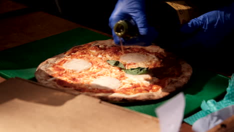 chef pouring olive oil on pizza outside a music festival