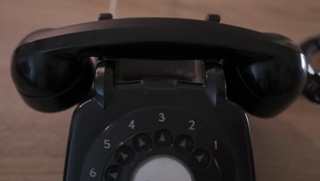 close-up of shot of a hand picking up and hanging up the receiver on a rotary dial phone