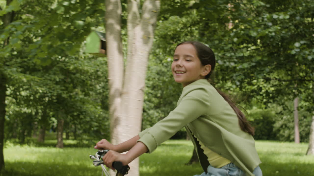 chica montando una bicicleta en el parque