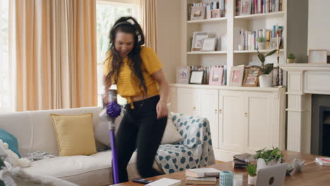 adolescente feliz bailando en casa usando auriculares usando aspiradora divirtiéndose bailando escuchando música limpiando la casa haciendo tareas el fin de semana celebrando un estilo de vida despreocupado