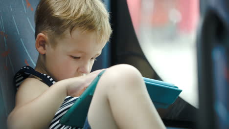 little boy in car using tablet computer