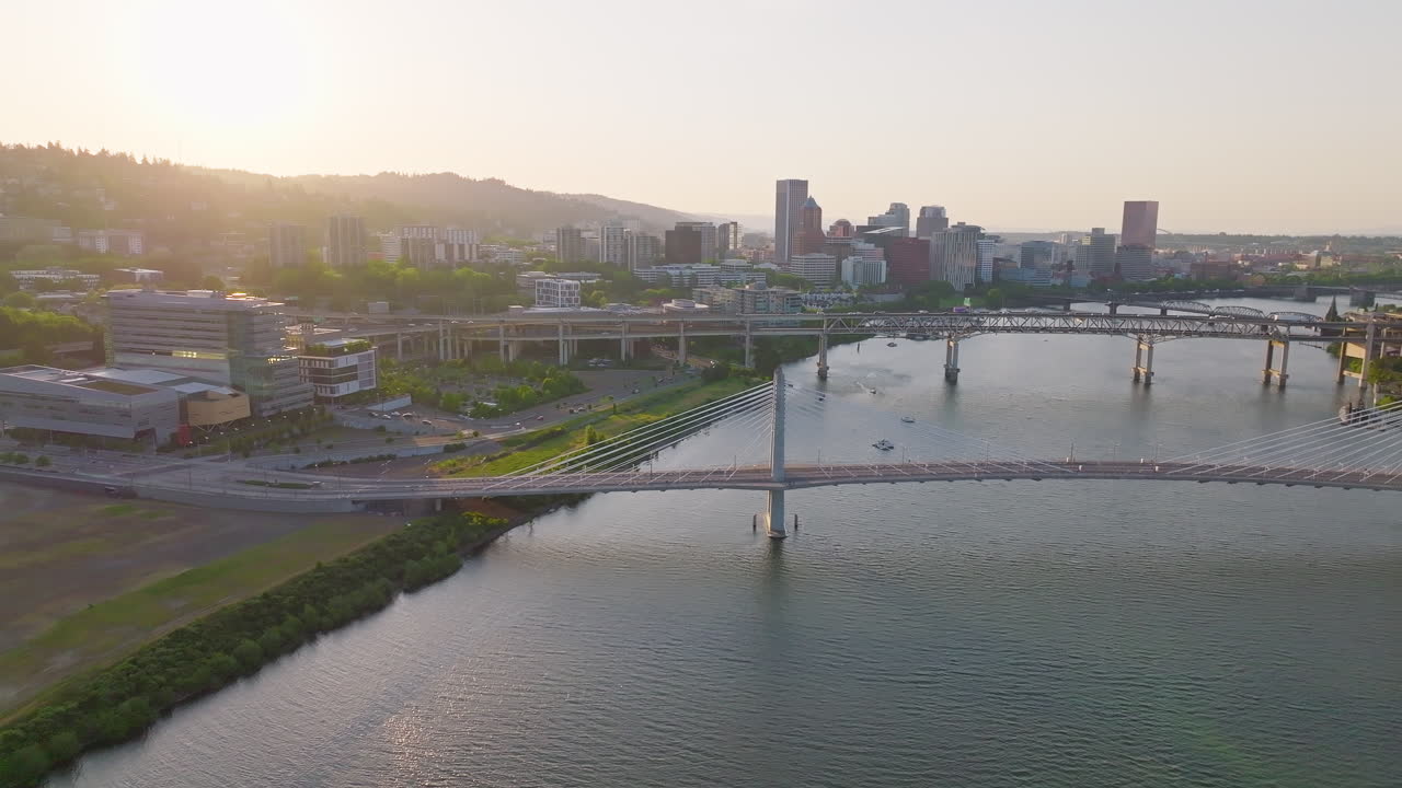 Beautiful twilight aerial of Portland, Oregon's Willamette River, bridges, and west hills. Wide shot, camera flies forward.