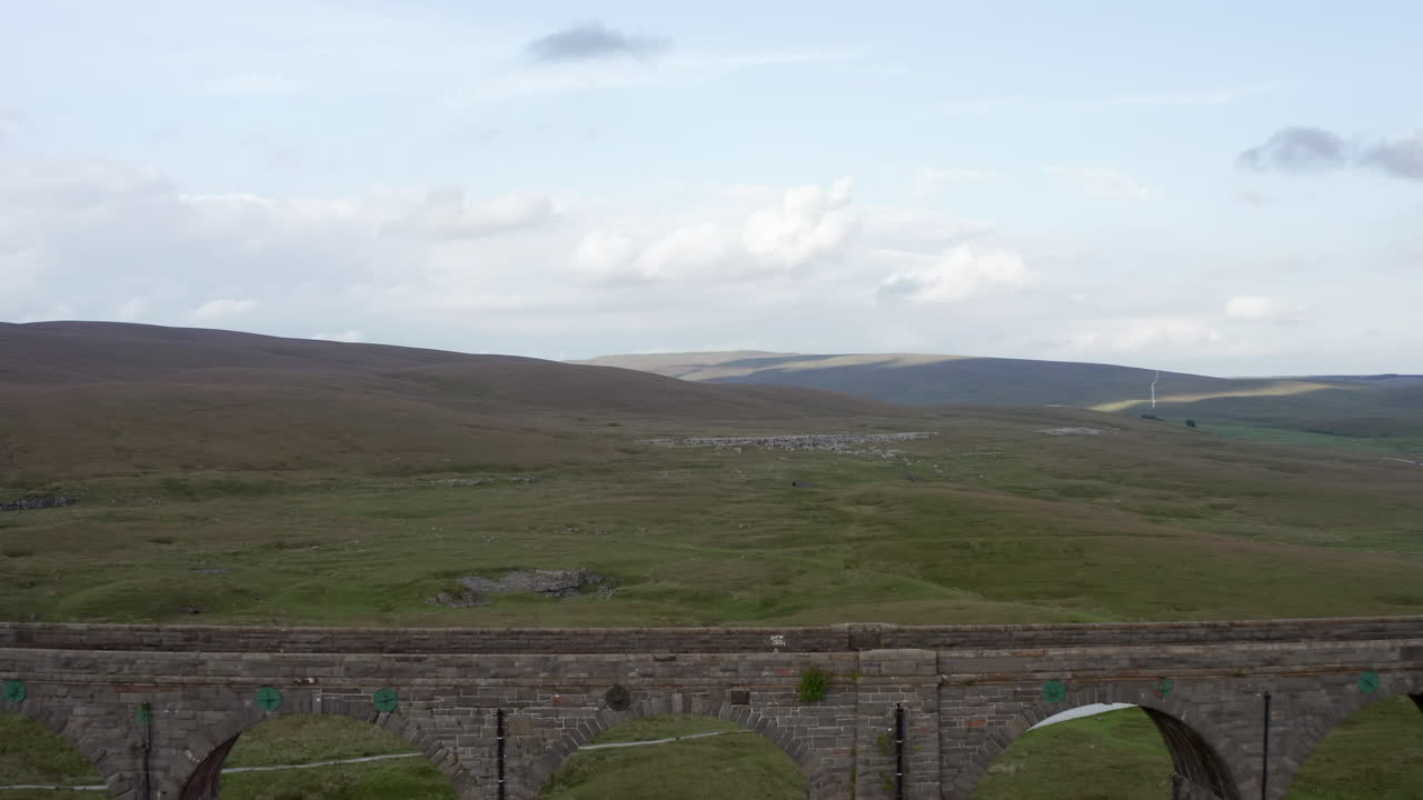 toma aérea de carro que revela el viaducto ribblehead en el parque nacional de los valles de yorkshire