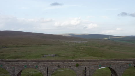 Toma-Aérea-De-Carro-Que-Revela-El-Viaducto-Ribblehead-En-El-Parque-Nacional-De-Los-Valles-De-Yorkshire