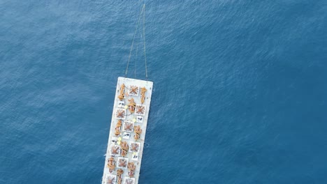 Tugboat-pulling-a-large-barge-carrying-components-of-a-artificial-reef-structure