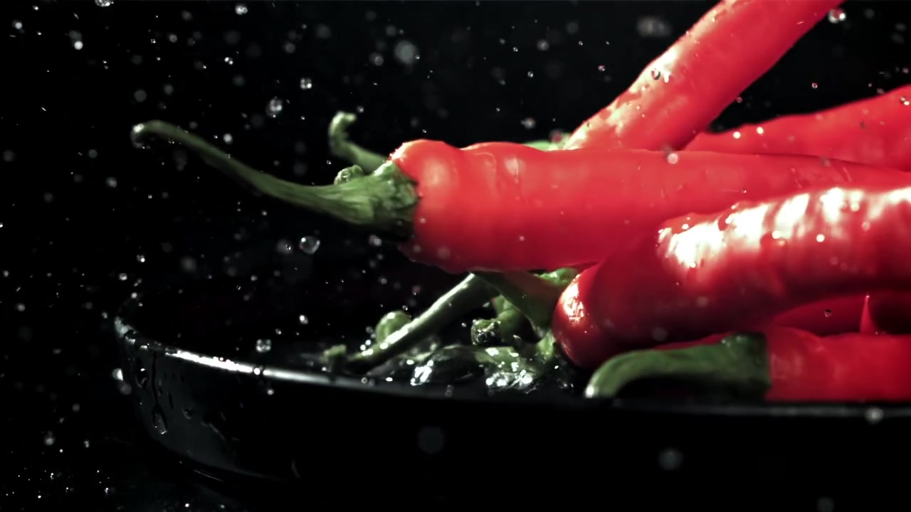 Fresh Red Chili Peppers Falling into Water with Splashes