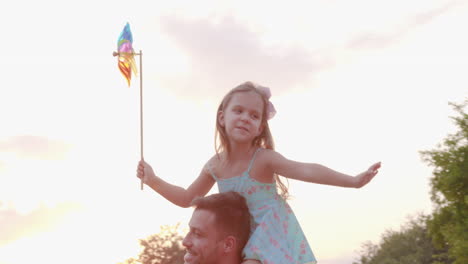 daughters riding dads shoulders holding