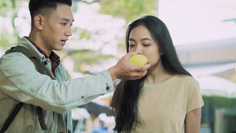 handheld view of vietnamese couple choosing fruit at the market