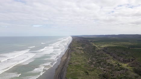 Weitwinkel-Luftumlaufbahn,-Die-Die-Lange-Westküste-Der-Neuseeländischen-Nordinsel-Mit-Reifenspuren-Im-Schwarzen-Sand-Darunter-Zeigt