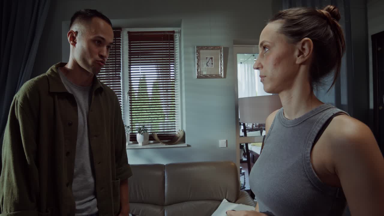 una pareja discutiendo en la sala de estar.