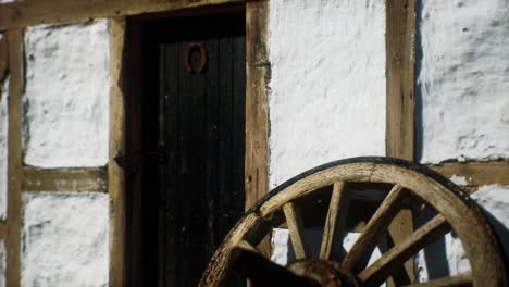 old wood wheel and black door at white house