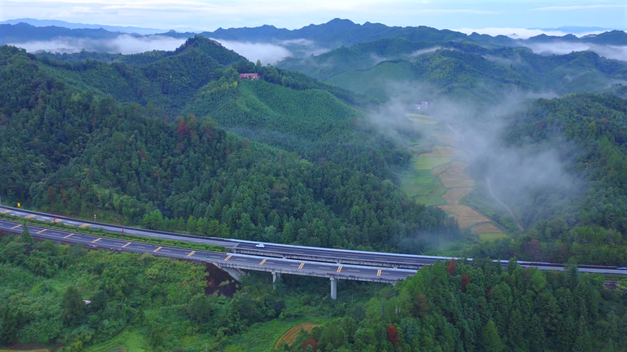 The car is driving on a foggy road, with beautiful scenery and natural scenery during the journey Aerial photography of highways under clouds and mist