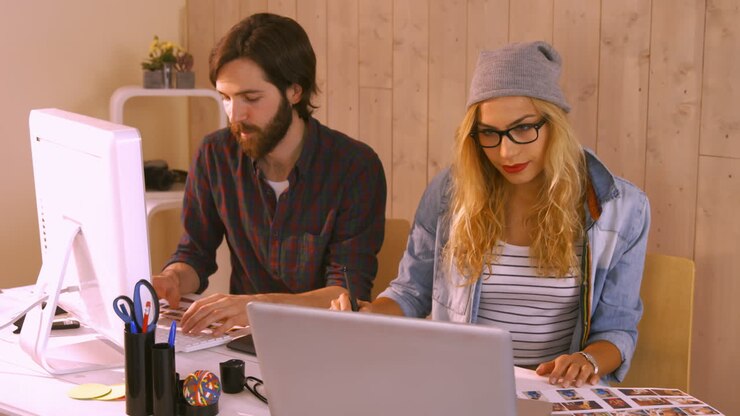 Afslappede designere arbejder på laptop og grafisk tablet