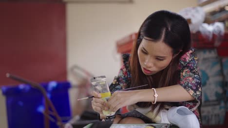 young asian woman engaged in crafting or painting activity