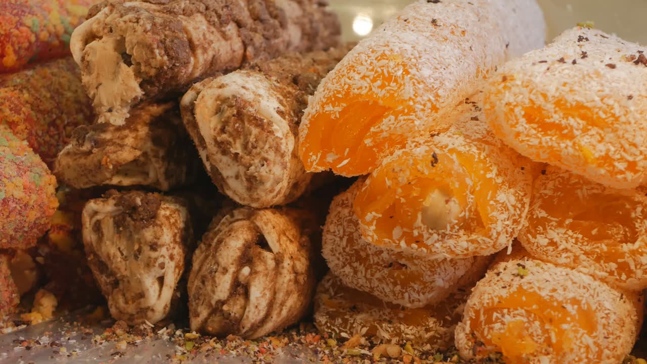 Turkish delight of various flavors is sprinkled with chocolate and coconut flakes. Dolly shooting Turkish delight. 4K close-up