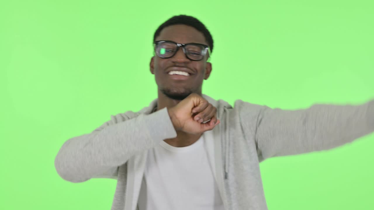 hombre africano bailando de alegría sobre un fondo verde
