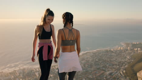 happy girl friends dancing on mountain top celebrating successful hiking adventure with funny victory dance