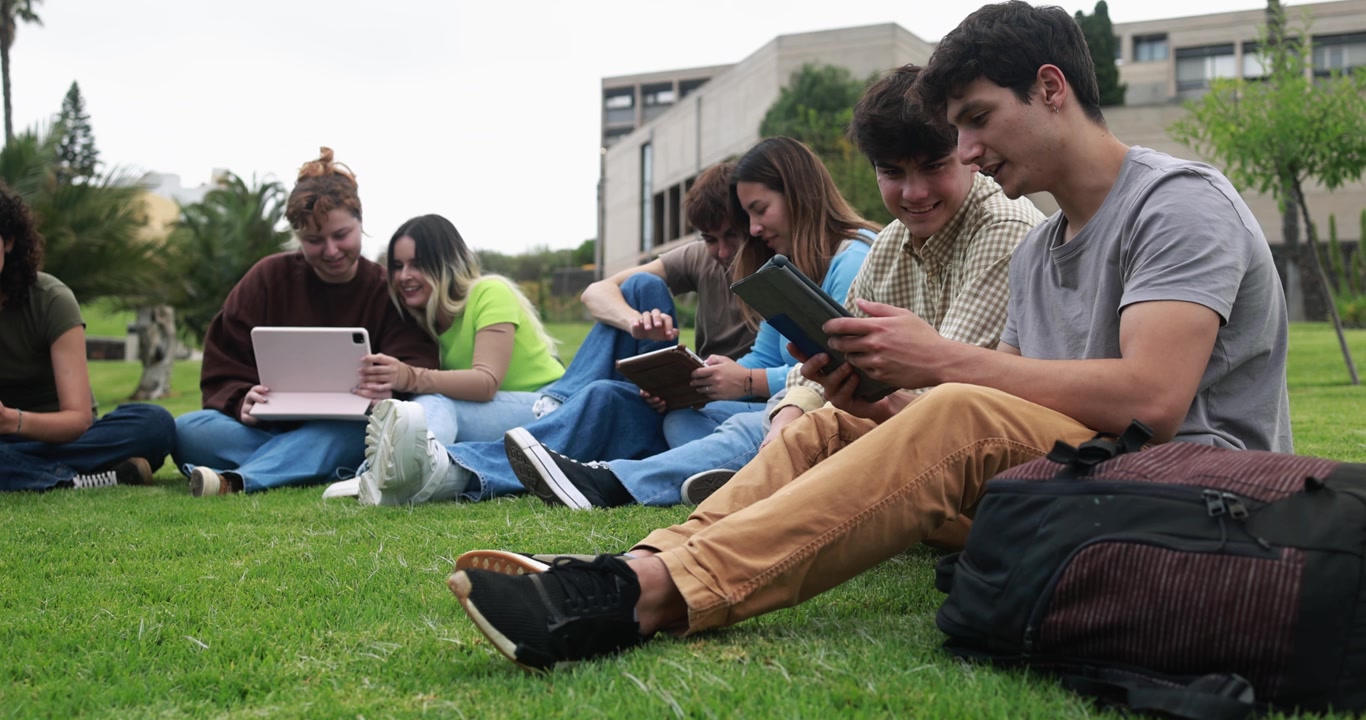 Gruppe studenter som bruker nettbrett sammen på universitetsplenen
