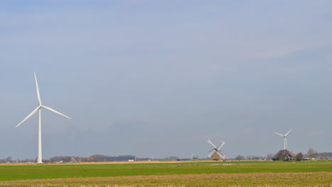 windturbines and an old windmill in an agricultural field in the netherlands, europe