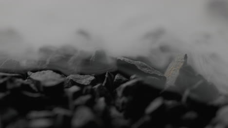 extreme close-up macro shot of smoke covering black stones