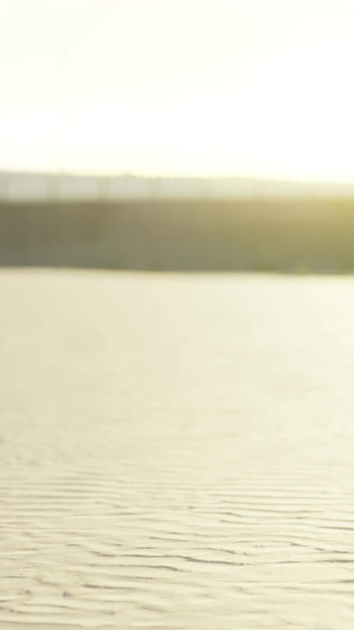 Sunset light on sandy surface near water body during evening time