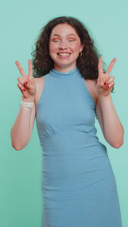 woman girl showing victory v sign hoping for success and win doing peace gesture with two fingers
