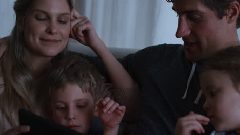 family using tablet computer mother and father watching children playing games on touchscreen device learning having fun enjoying quality time before bedtime 4k