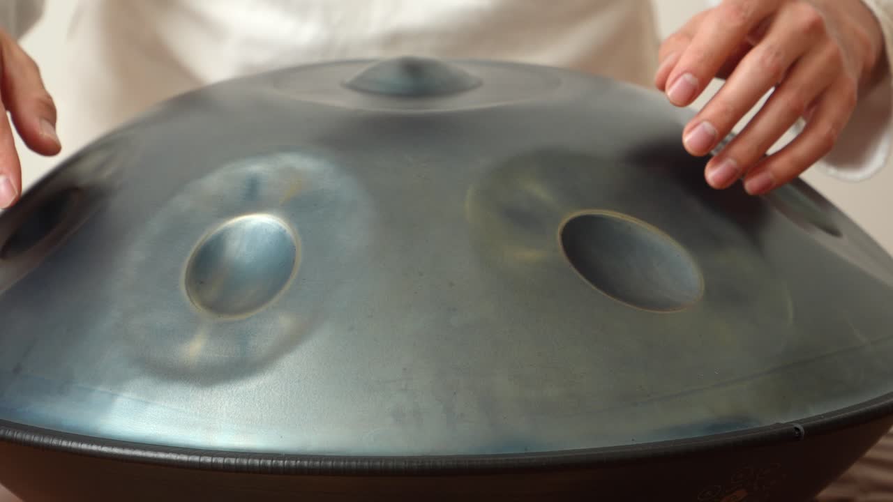 Close-up shot of a man performing on a handpan drum