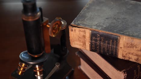 an antique microscope an ancient anatomy reference book in a doctor or veterinarian's office desk