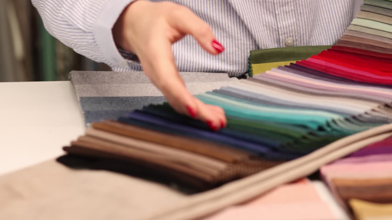 Close-up of a person's hand browsing fabric color swatches