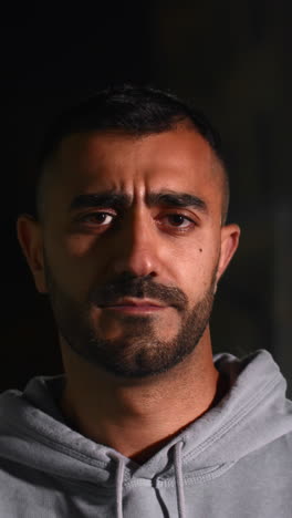 close-up portrait of a man wearing a gray hoodie