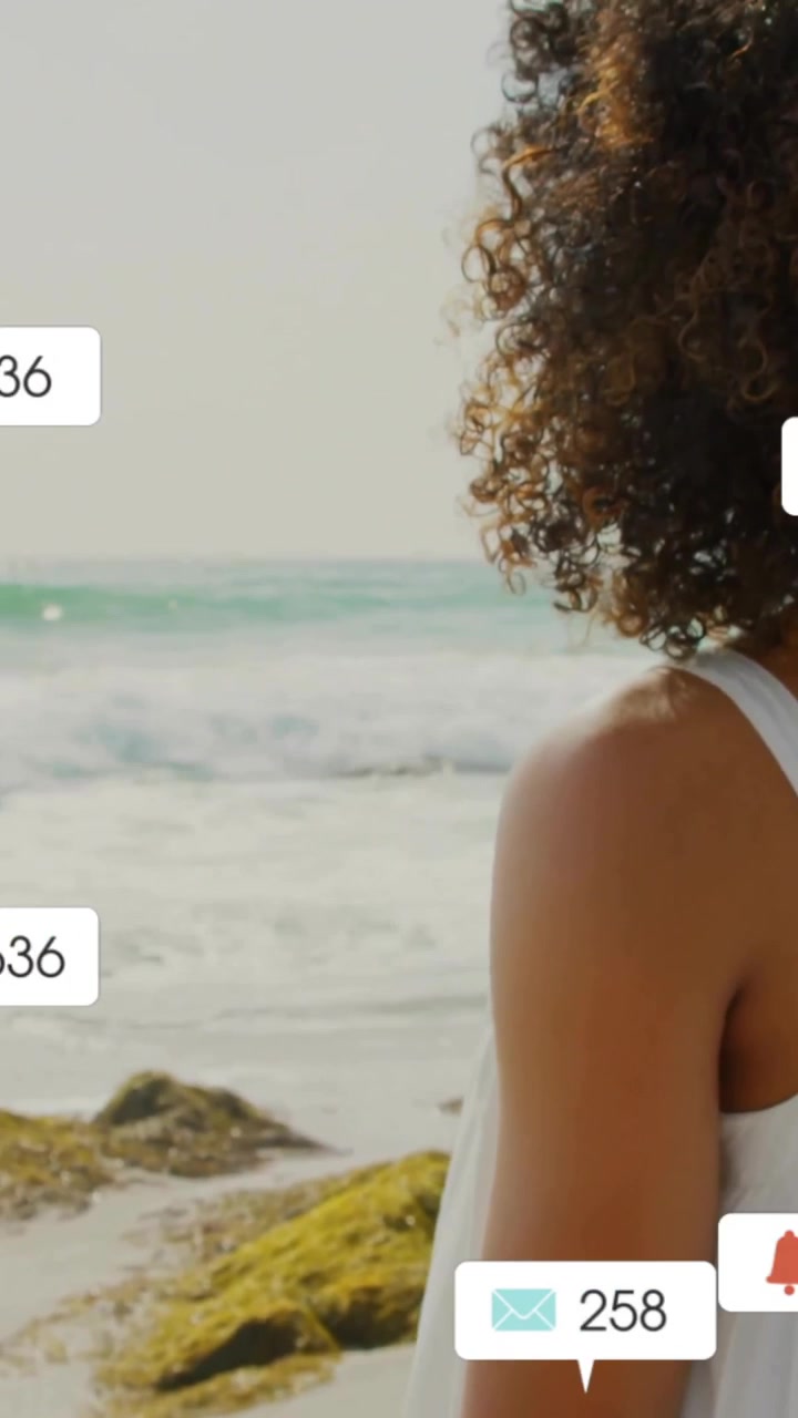 Social media notifications animation over woman standing on beach