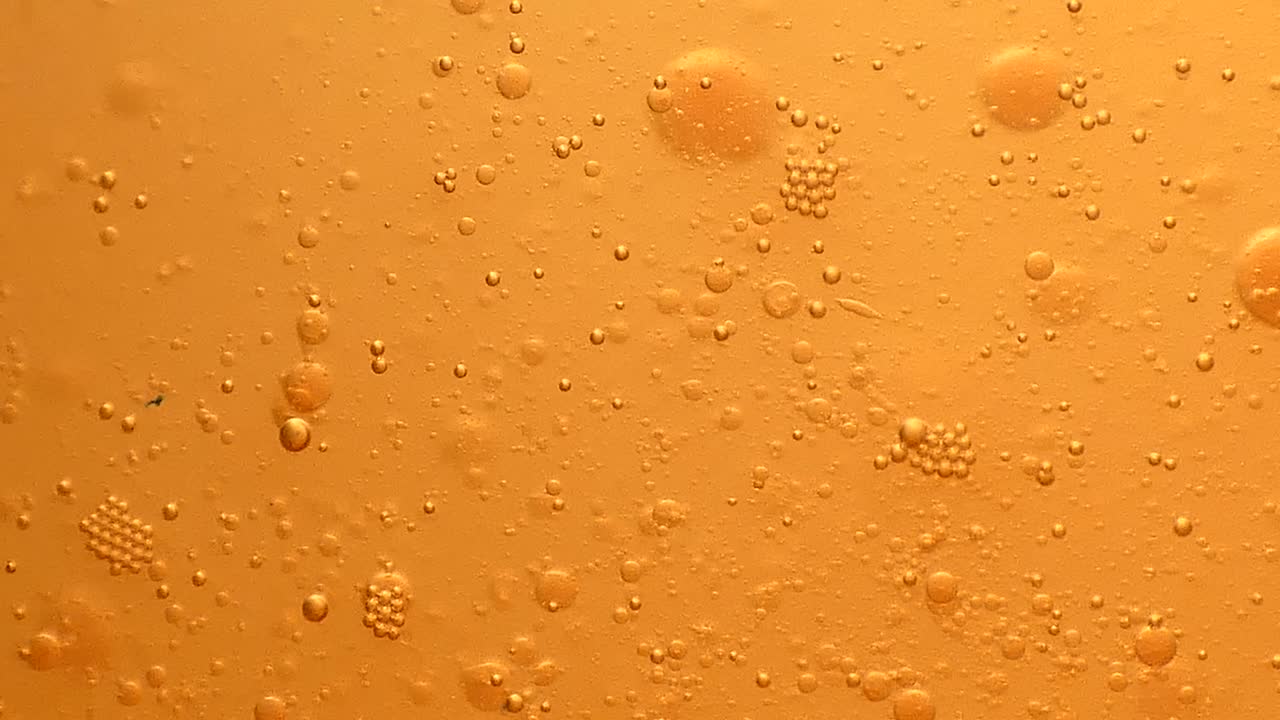 Bolle d'olio color bronzo che galleggiano e scendono