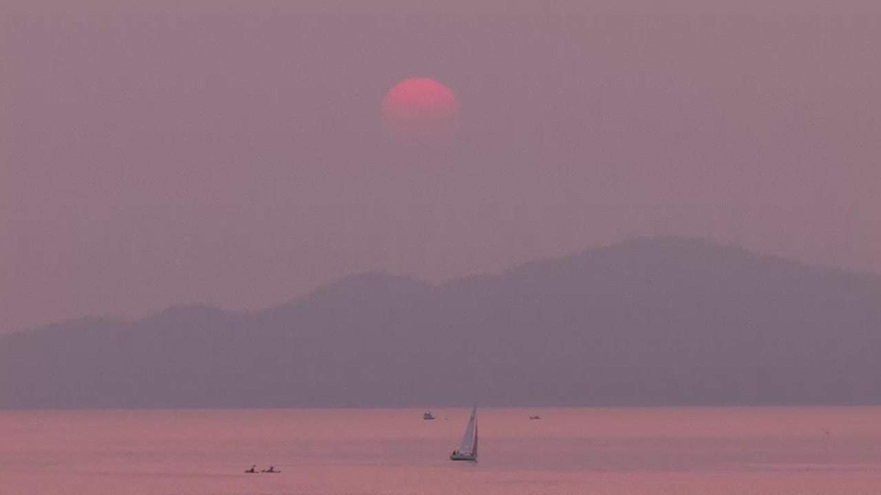Sailboat moving through smoke. Smoke filled sky