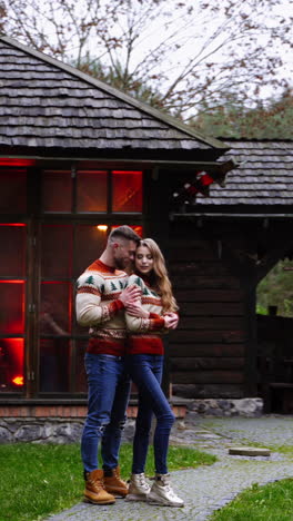 romantic couple in the yard. young guy and his girlfriend having a date on terrace in warm autumn day. lovely couple stands at front yard of cottage. vertical video
