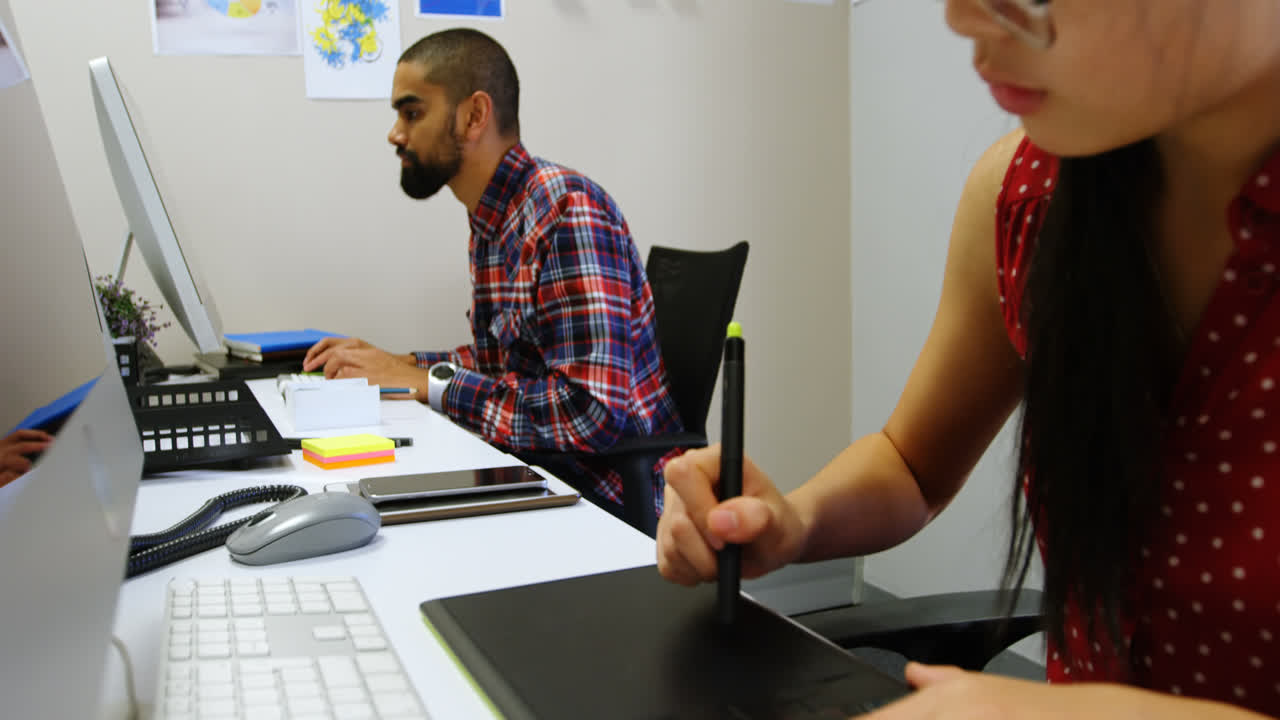 diseñador gráfico usando tableta gráfica en la oficina 4k