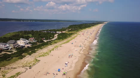 Drone-shot-of-Atlantic-Ocean-and-bay-with-shore-houses,-beach,-boats,-and-boardwalk