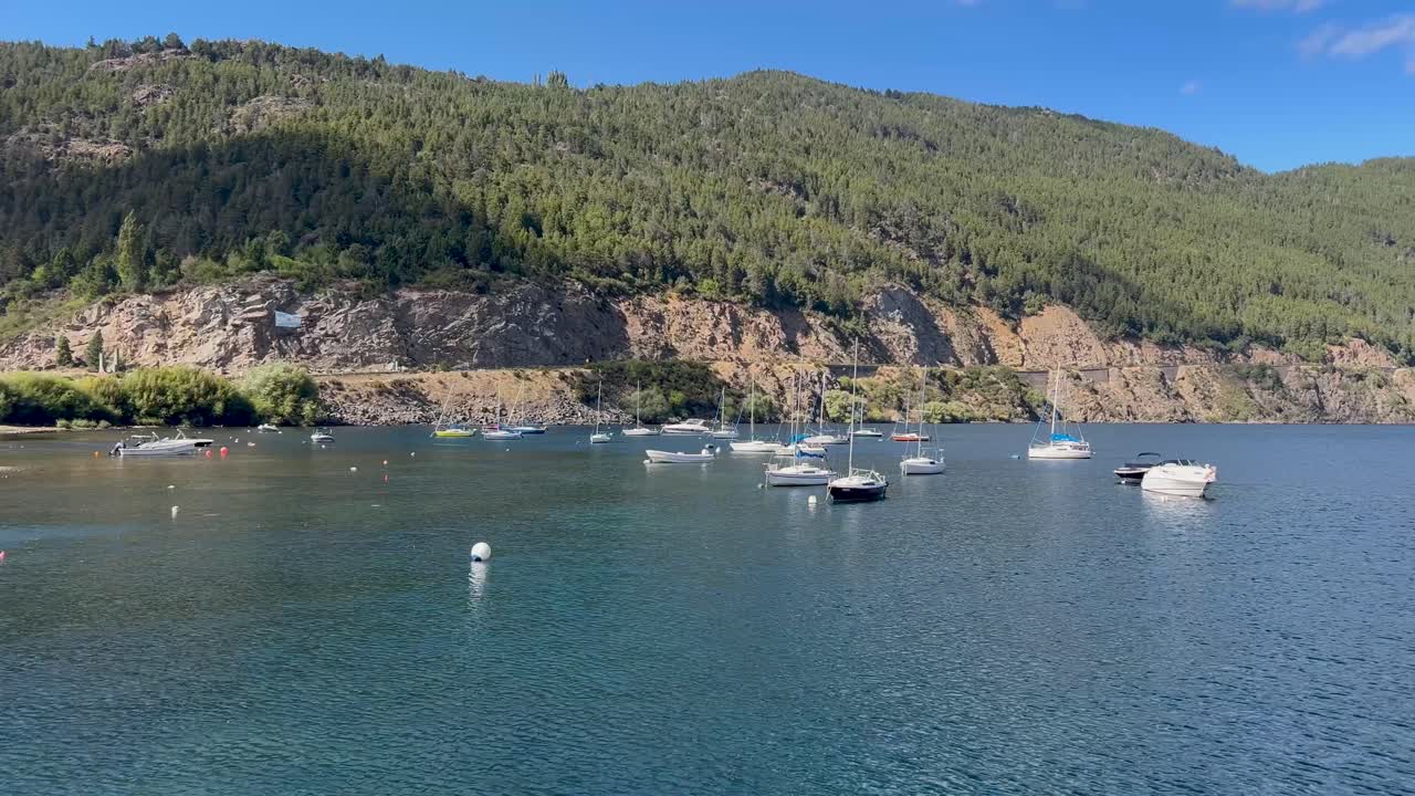 A serene marina in San Martín de los Andes with boats docked, surrounded by lush green hills