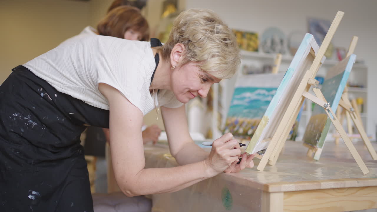 행복한 친구 그룹 세니오 사람들은 수업에서 함께 그림을 그리고 함께 토론하고 웃습니다.