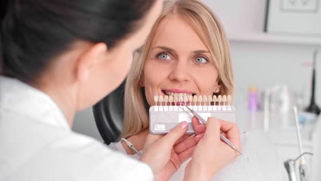 Close-up-of-dentist-choosing-color-teeth-from-palette