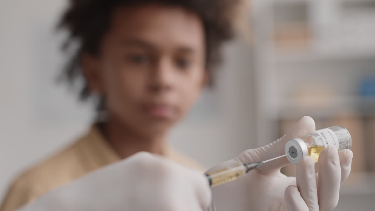 manos con guantes llenando la jeringa