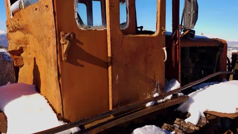 Iron-Chains-of-Old-Tractor-Relics-Resting-Against-a-Snowy-Mountain-Landscape,-a-Winter-Nostalgia-Through-Rustic-Countryside-Scenery