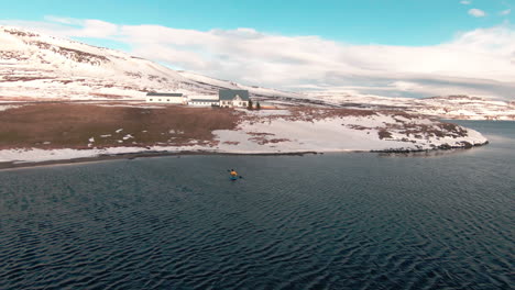 Lonely-caucasian-tourist-paddling-on-kayak-in-winter-landscape