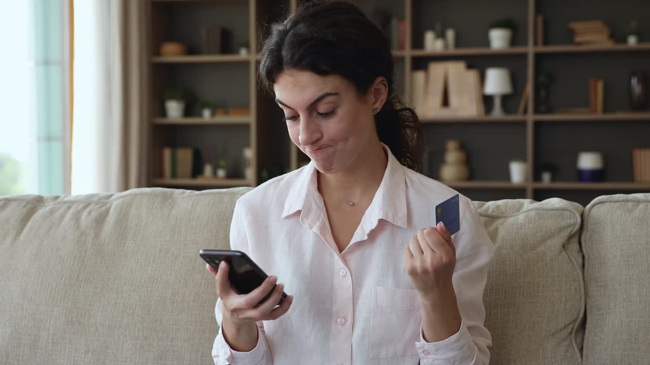 una mujer con una tarjeta de crédito en un teléfono inteligente experimenta problemas con el pago electrónico