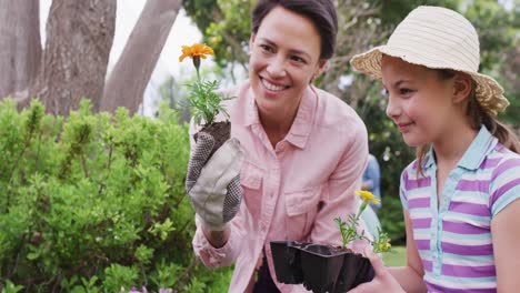 Glückliche-Kaukasische-Mutter-Und-Tochter,-Die-An-Einem-Sonnigen-Tag-Im-Garten-Arbeitet