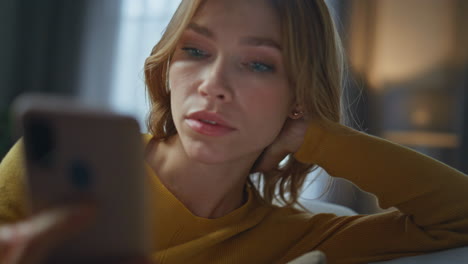 napping woman waking up taking smartphone at evening closeup. lady receiving sms