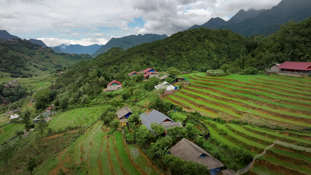 Aerial orbit above Sapa Valley’s lush green terraces and rural farmland landscapes on overcast day