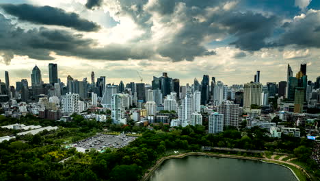 drone hyperlapse view over benchakitti park and lake ratchada of bangkok skyline