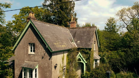 Rising-drone-shot-of-a-vacant-house-surrounded-by-overgrown-greenery