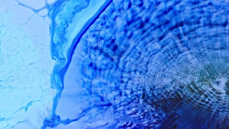 abstract blue ink diffusing in water creating a dynamic mix of patterns and textures, high-detail macro shot